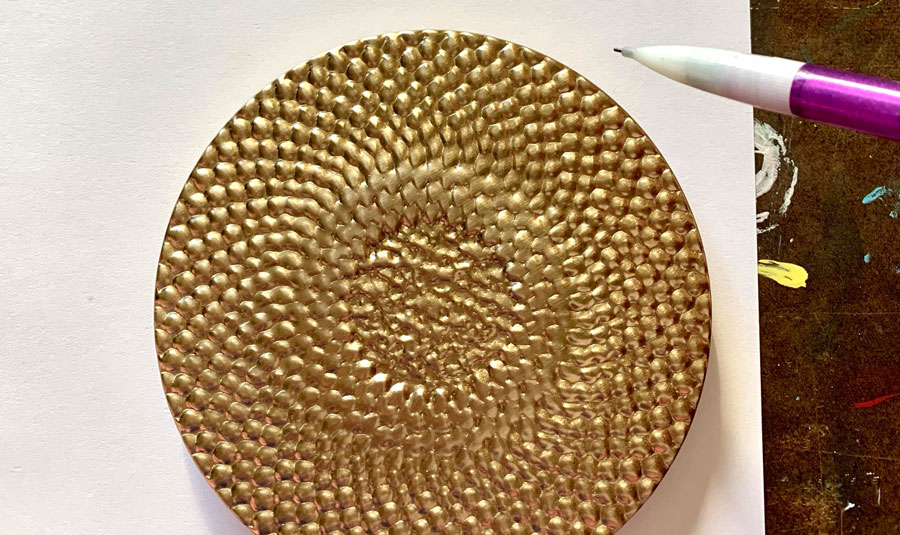 A round object being used to trace a perfect circle onto paper