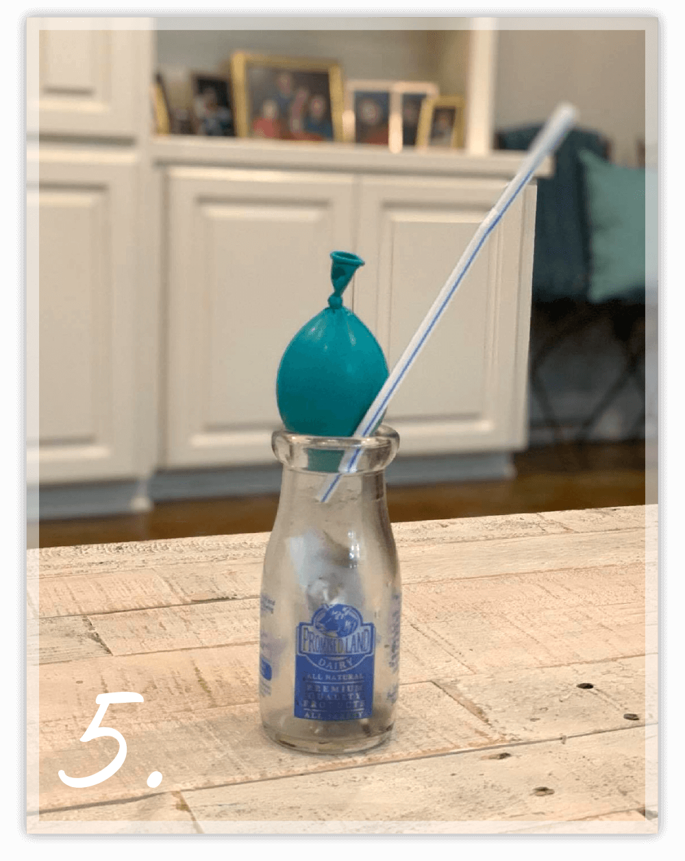 Balloon on a glass bottle with a straw sticking out of the bottle