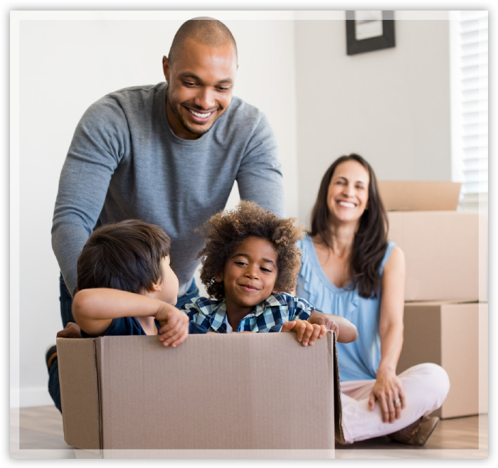 family of parents and children in cardboard boxes playing