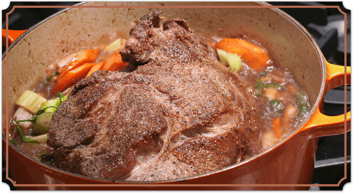close up of a pot of roast on a stove