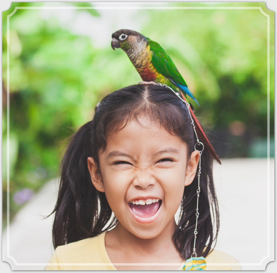 young girl with bird on her head