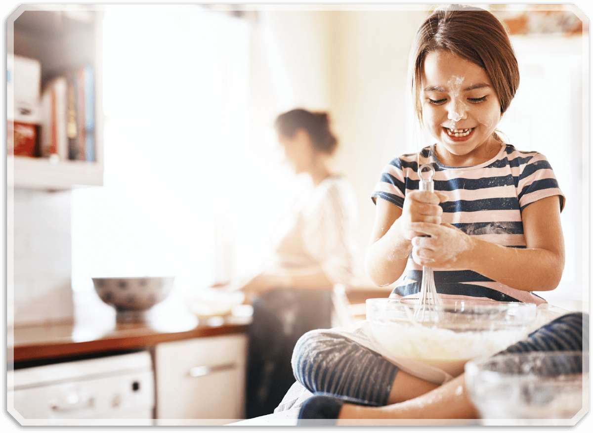 girl on counter mixing batter for baking