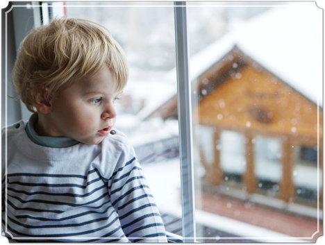 kid looking out window to snow