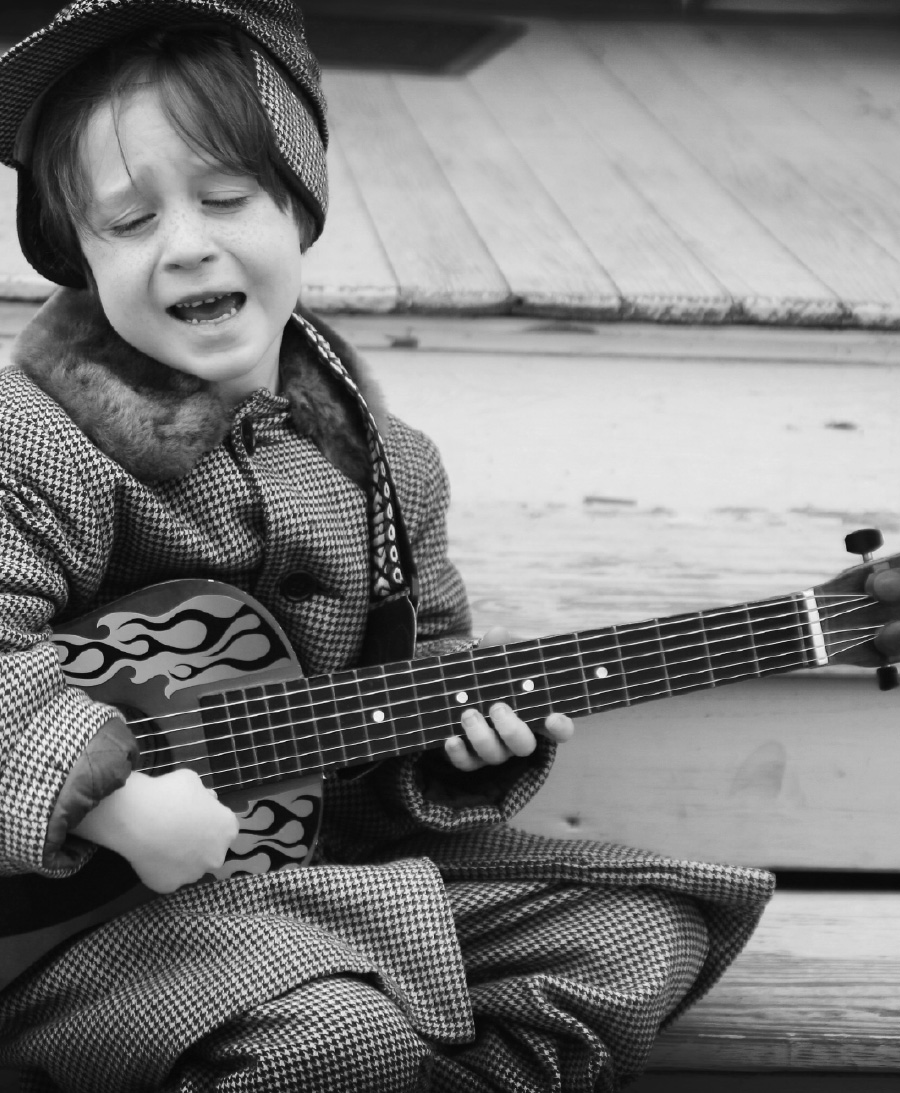 little boy playing guitar