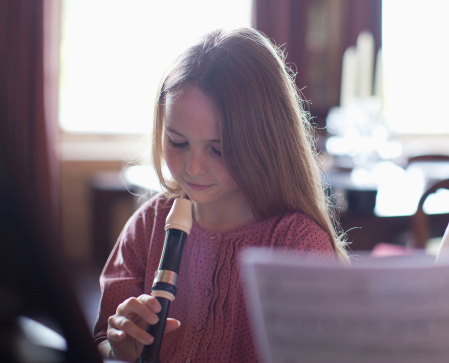 young girl playing the recorder