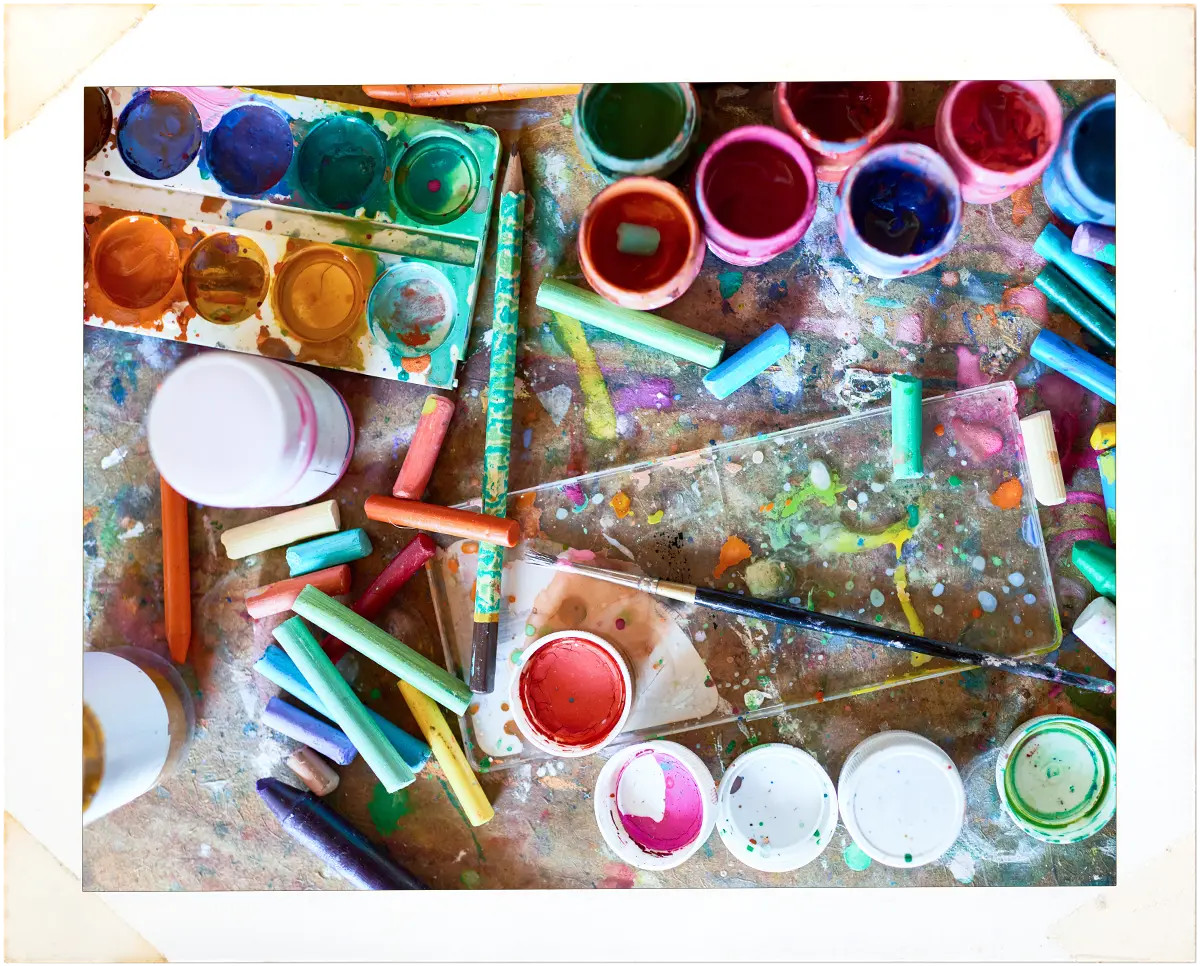 various paints and pastels on a table