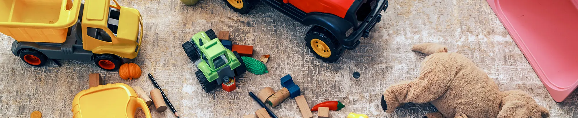 toy tractors, stuffed animals, and mini pumpkins laid out on the floor