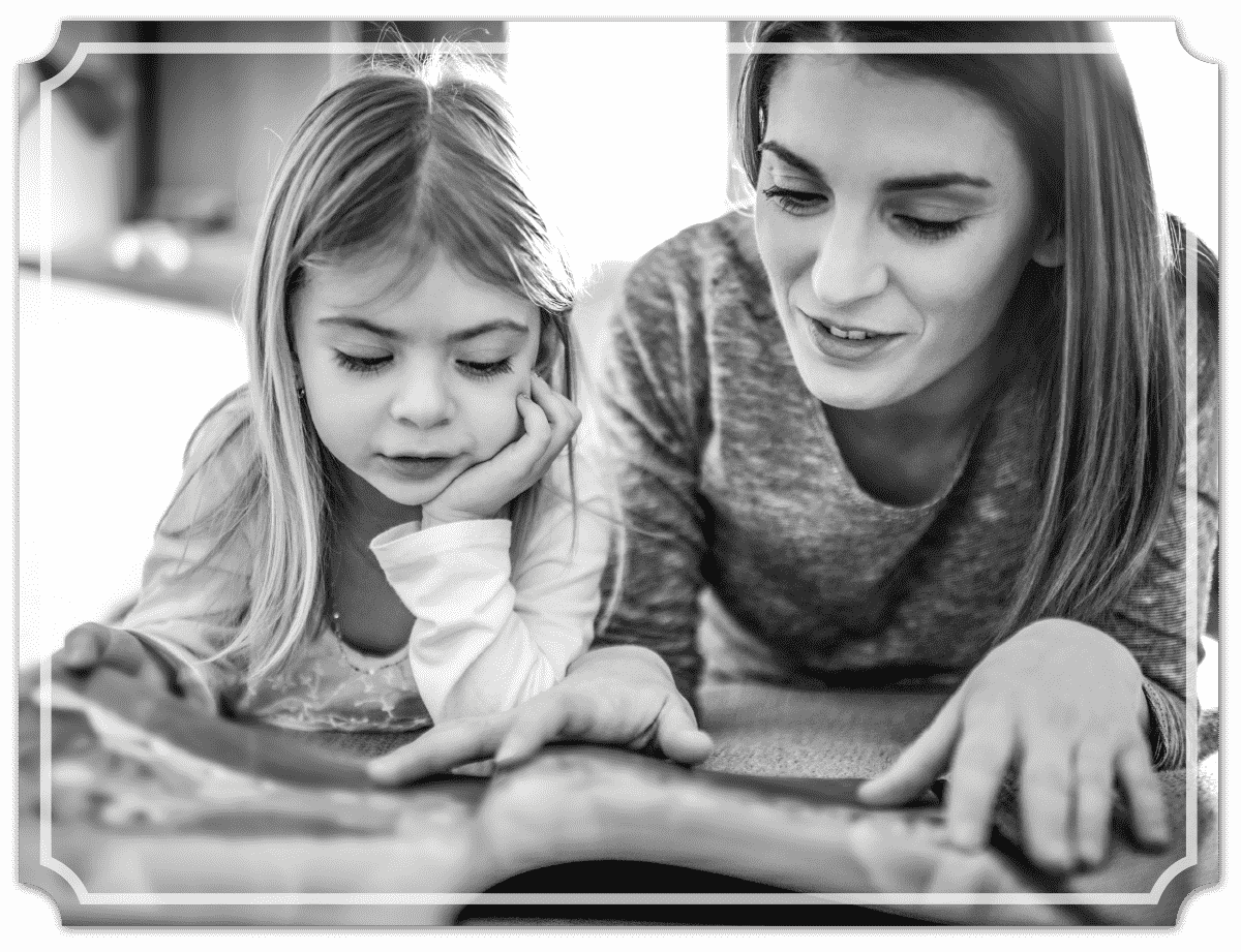 mom and daughter looking at a book together