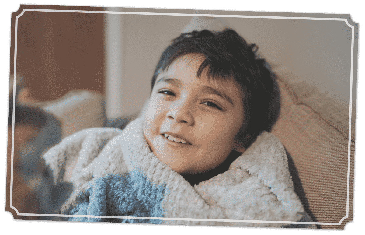 kid smiling while bundled up in blanket