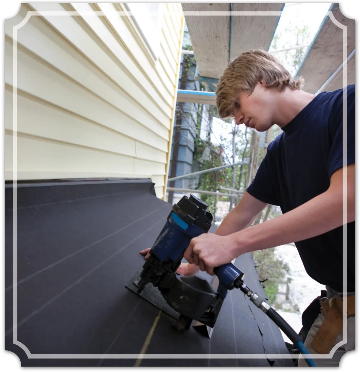 Portrait photograph of a teenage boy using a nail gun on a construction site black cover sheet outside a home
