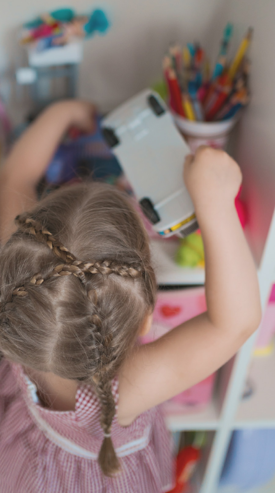 little girl at shelf grabbing toys