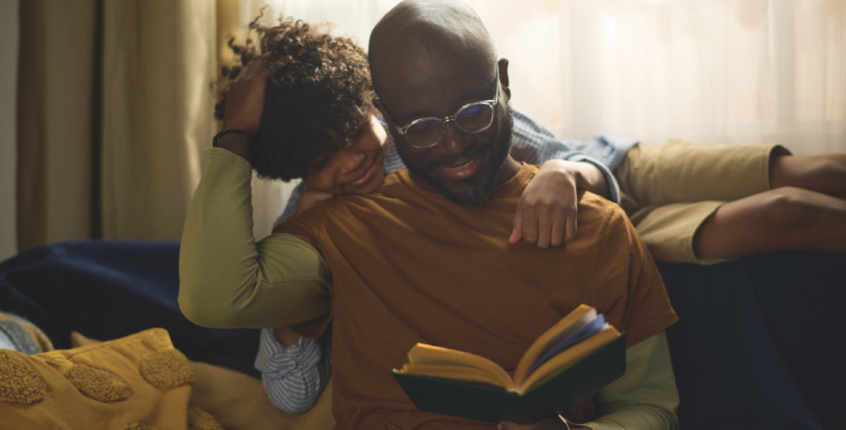 father and son looking at book together