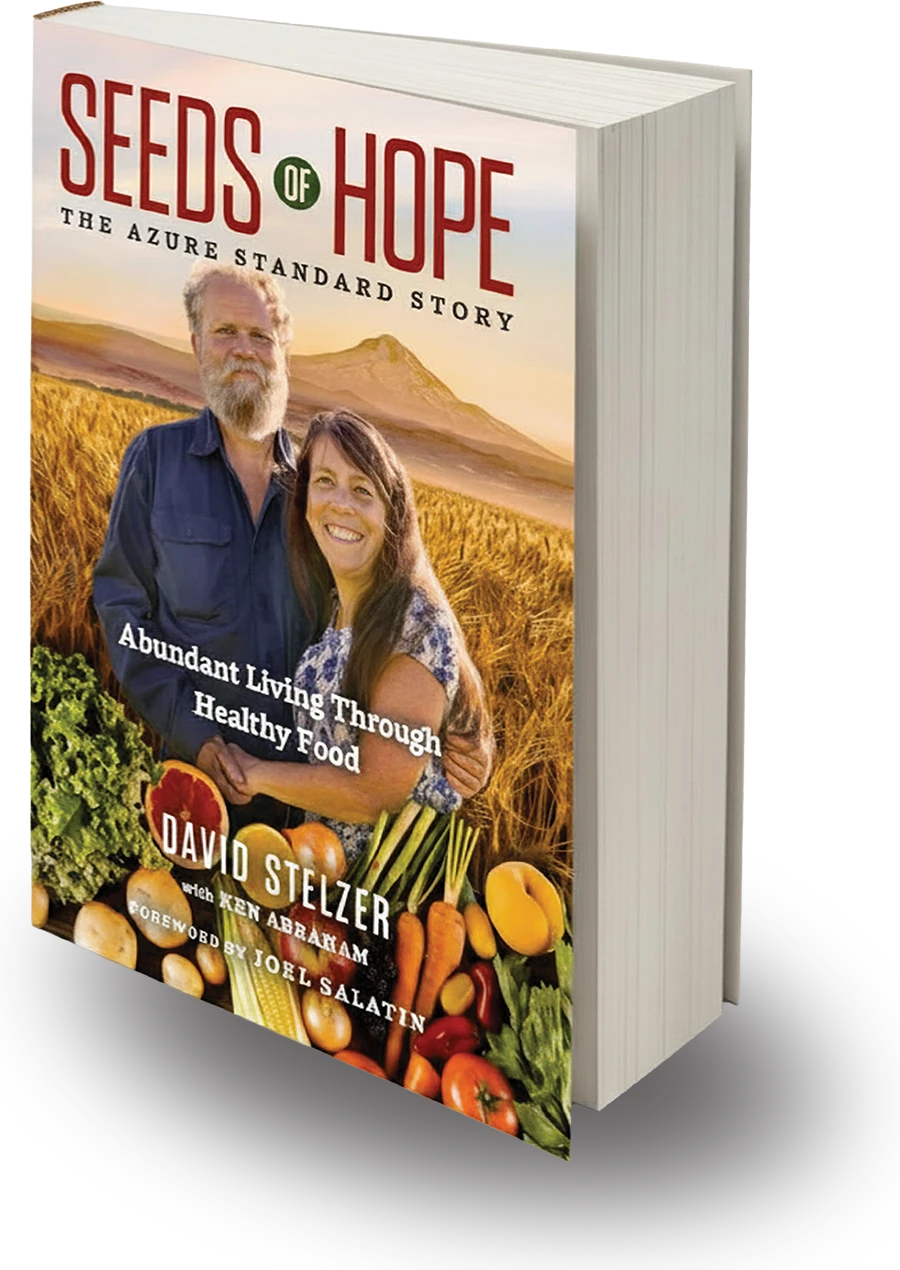 Book cover titled "Seeds of Hope: The Azure Standard Story" showing a smiling couple in a field with a basket of fresh produce.